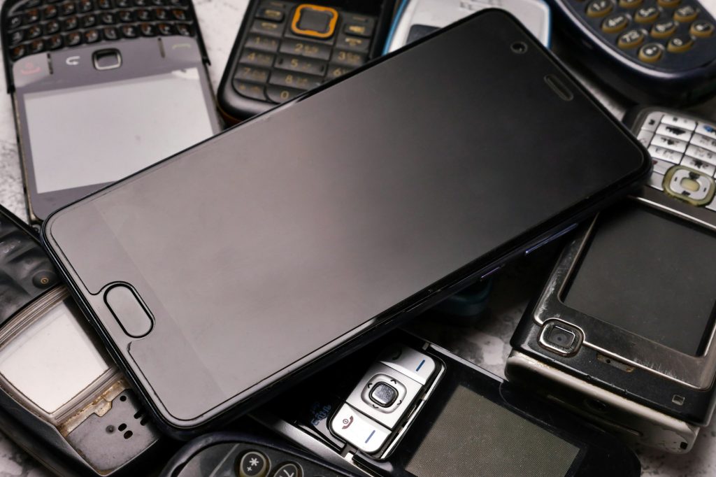 A smartphone on pile of obsoleted cellphones.