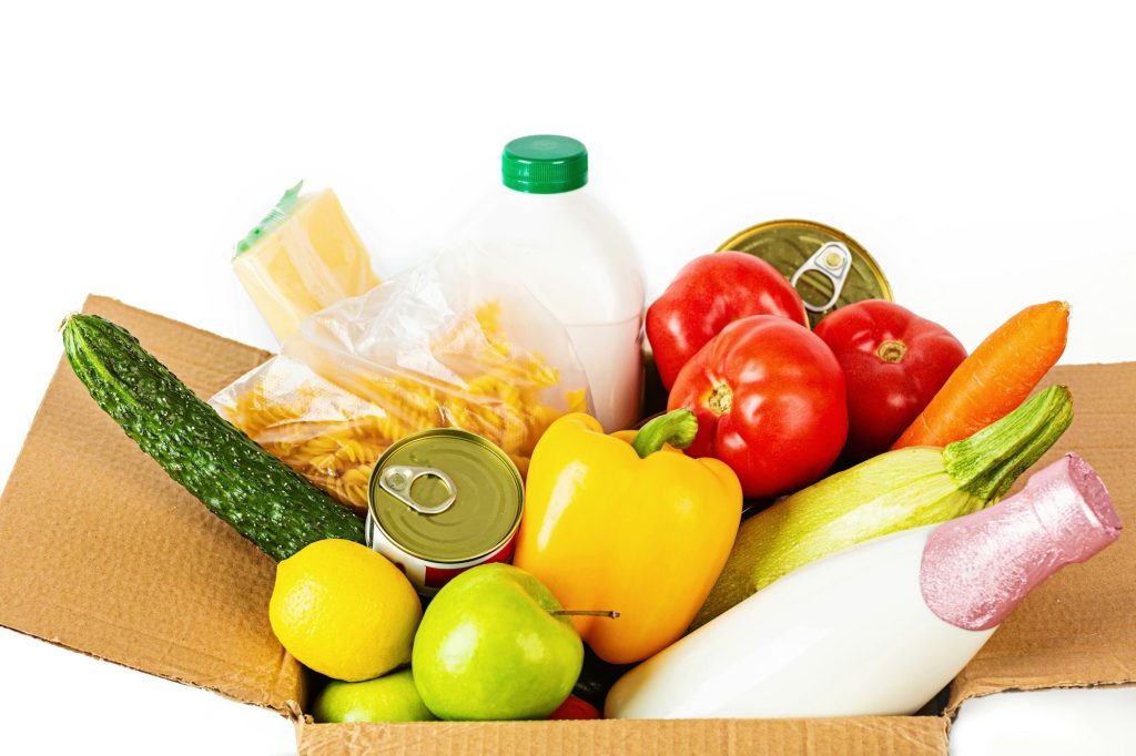 Donation box with food on white background. Assistance to people during coronavirus pandemic