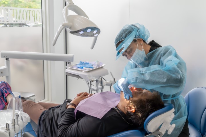 Dentist performing a dental procedure at Metropolitan Smile Design in Tamarac, Florida.