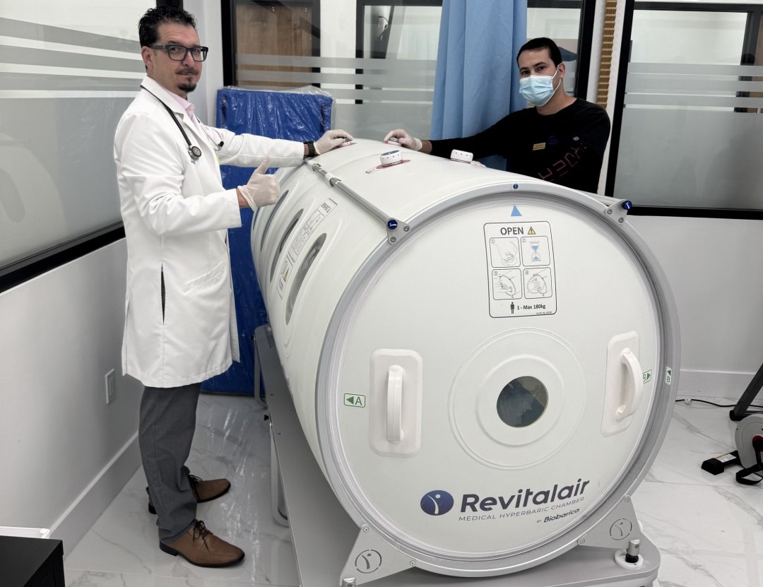 Doctor reviewing a senior patient's leg wound during a hyperbaric oxygen therapy evaluation at Metropolitan Medical Centers Tamarac
