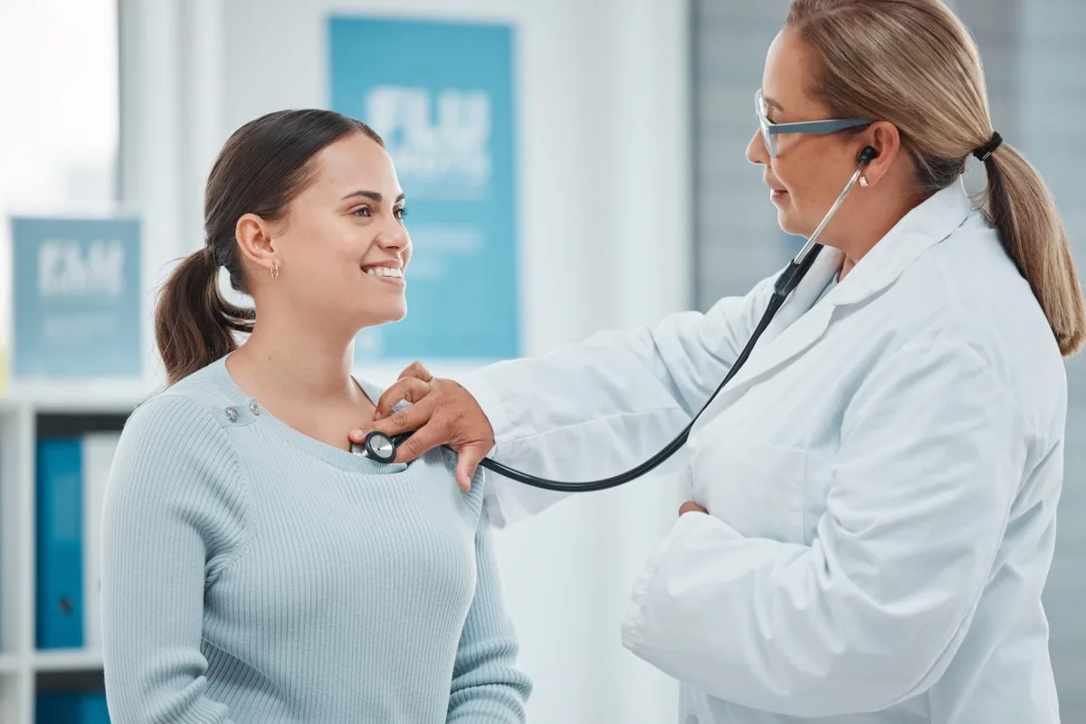 Ginecólogo en Tamarac: Qué Esperar del Chequeo de la Mujer Después de los 50 2 Una doctora ausculta con estetoscopio a una paciente durante una consulta en la clínica