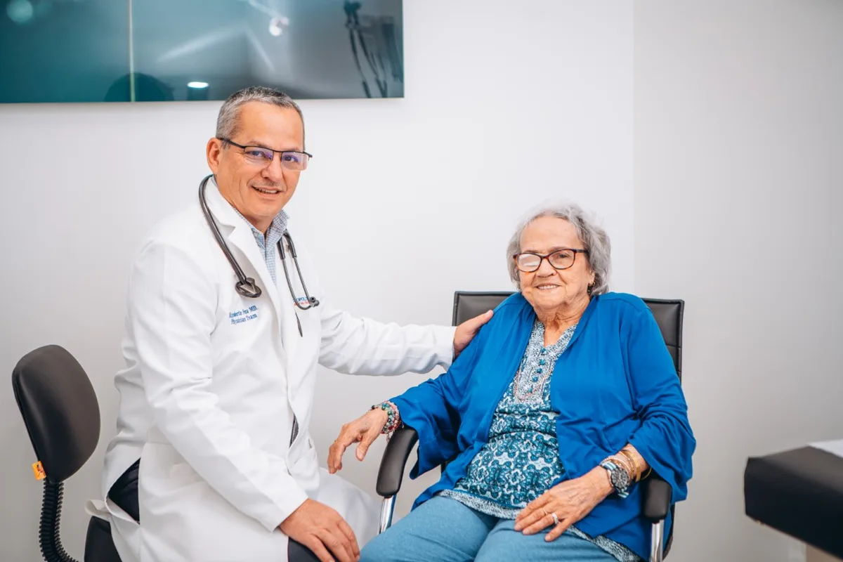 Ozone Therapy in Broward County: What It Is, What We Know, and What to Ask 2 A doctor in a white coat sits beside an older woman in a blue cardigan during a visit at the clinic